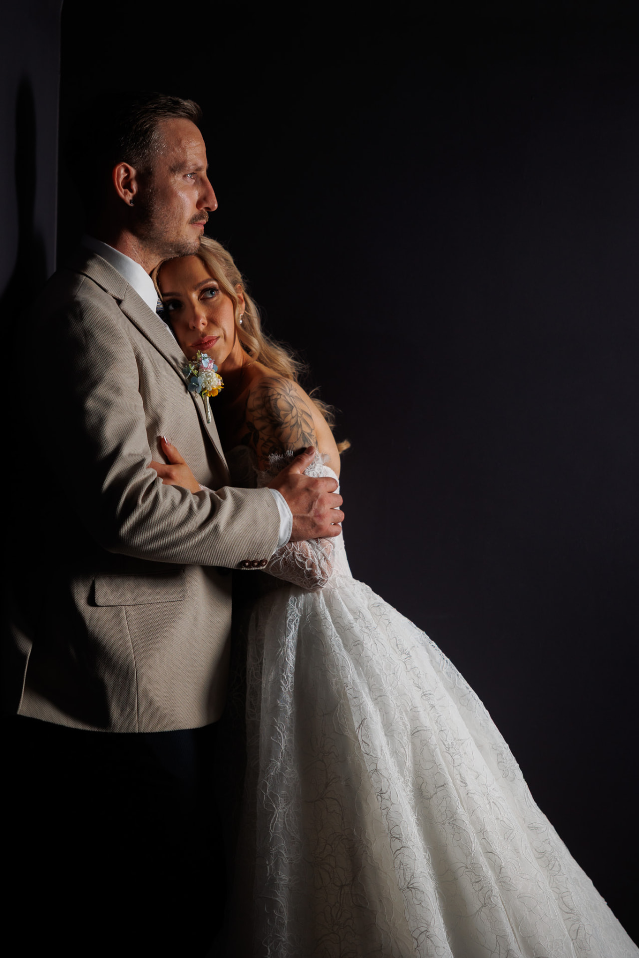 Bride and groom in low light against a dark wall